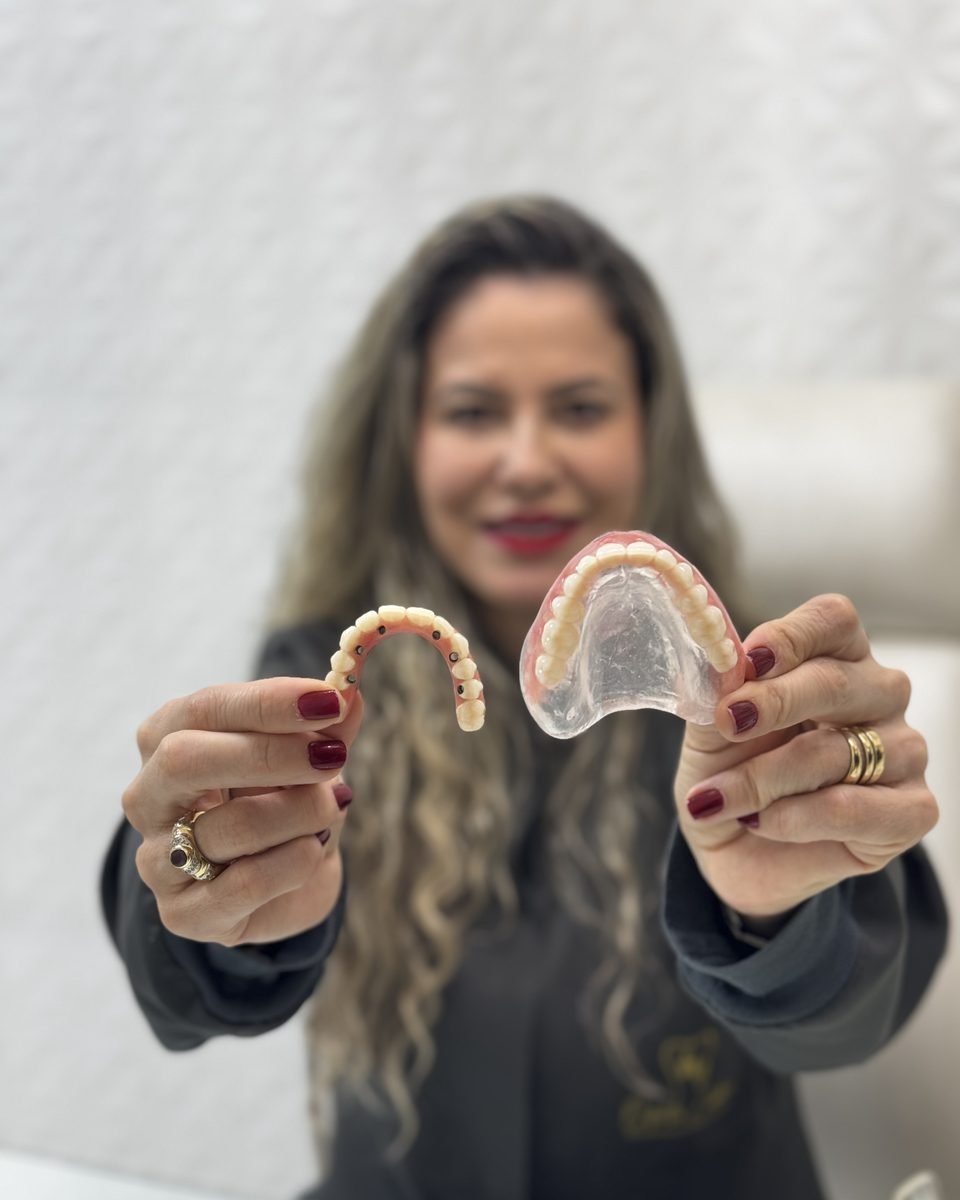 Dra. Patrícia Castro segurando uma prótese protocolo e uma dentadura convencional